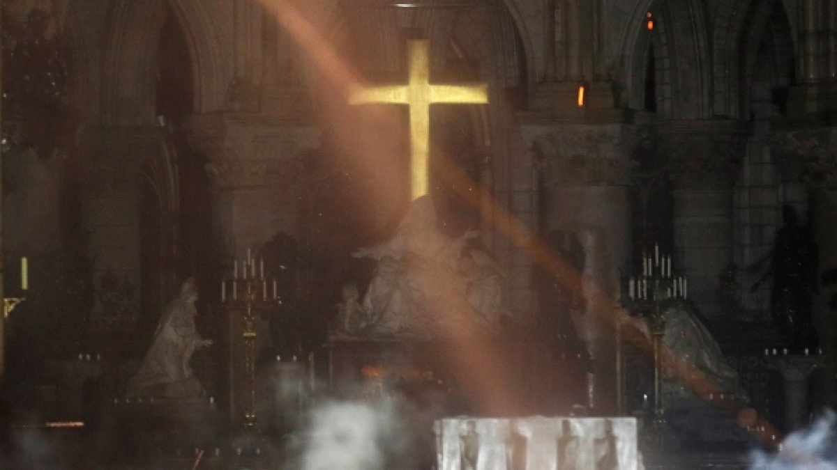 Der Altar der Kathedrale Notre-Dame ist am 15.04.2019 bei einem verheerenden Feuer von Rauch umgeben (oben) und der damalige Erzbischof von Paris, Andre Vingt-Trois, bei einer Messe in der Kathedrale 2015. (Foto)