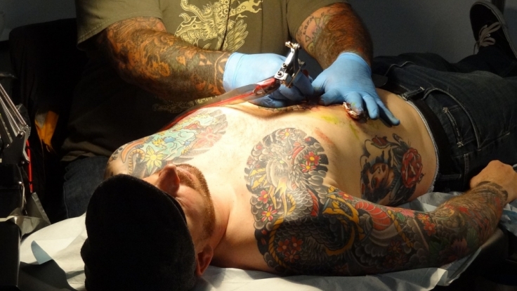 Nekrotisierende Fasziitis Mann geht mit frischem Tattoo schwimmen