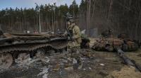 Ein ukrainischer Soldat läuft an zerstörten russischen Panzern vorbei.
