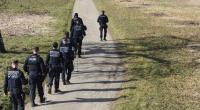 Mehrere Einsatzkräfte der Polizei suchen ein Gebiet rund um den Fundort der Babyleiche ab.