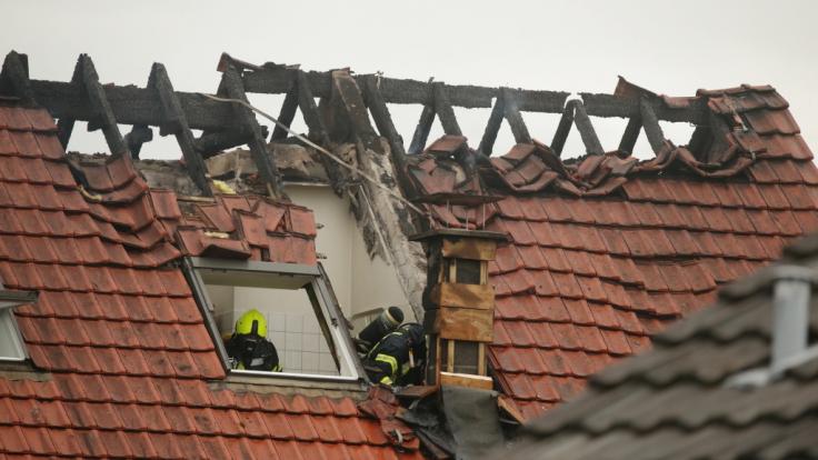 Feuerwehrleute suchen in einem beschädigten Wohnhaus nach Spuren. Bei dem Absturz eines Ultraleichtflugzeugs auf das Mehrfamilienhaus im niederrheinischen Wesel sind am Samstag drei Menschen gestorben.
