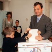 Viktor Orban steht gemeinsam mit seinen Kindern Gaspar (l.), Sara (M., verdeckt von Wahlzettel), Rahel (Hintergrund, r.) und seiner Frau Aniko Levai in einem Wahllokal 1998.