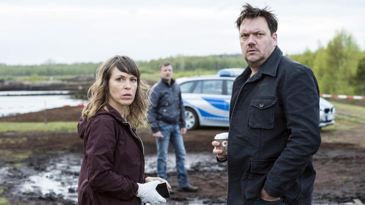 Die Kommissare Katrin K&ouml;nig (Anneke Kim Sarnau), Alexander Bukow (Charly H&uuml;bner, r) und Anton P&ouml;schel (Andreas Guenther, Hintergrund) stehen am Tatort - eine Szene des Krimis "Polizeiruf 110: In Flammen". (Foto)