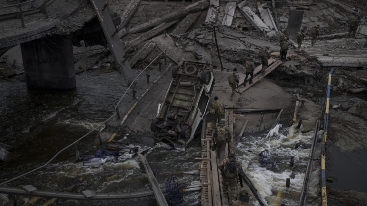 Ausl&auml;ndische und ukrainische Soldaten &uuml;berqueren einen improvisierten Weg unter einer zerst&ouml;rten Br&uuml;cke in Irpin nordwestlich von Kiew. (Foto)