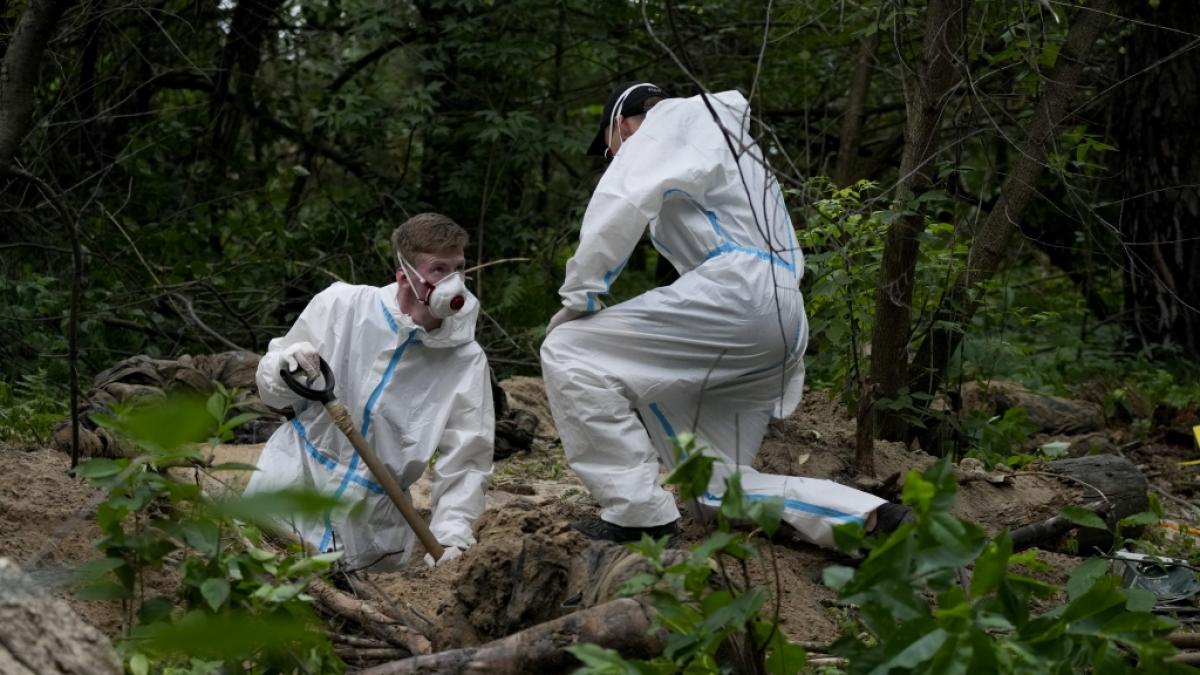 Zwei Ermittler in Schutzkleidung arbeiten w&auml;hrend einer Exhumierung an einem Massengrab in der N&auml;he von Butscha am Stadtrand von Kiew. (Foto)
