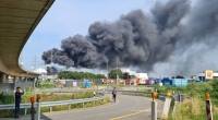Eine dunkle Rauchwolke steigt über dem Chemiepark Leverkusen auf. Einsatzkräfte der Werkfeuerwehr sind im Einsatz.