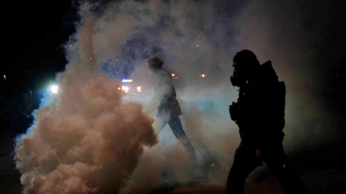 Ein Beamter der Einwanderungsbeh&ouml;rde steht inmitten einer Tr&auml;nengas-Wolke am Tatort einer gemeldeten Schie&szlig;ere in Minneapolis. (Foto)