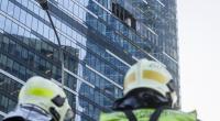 Feuerwehrmänner begutachten die Schäden am Hochhaus der Stadtverwaltung in der 