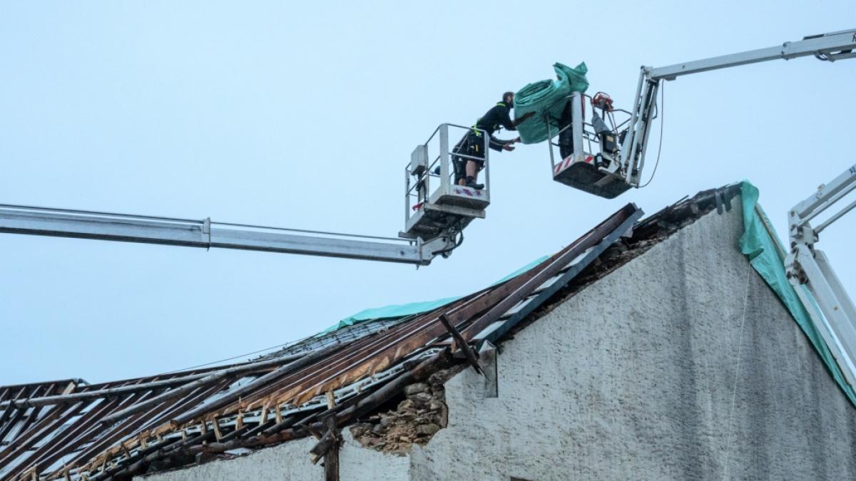 Einsatzkr&auml;fte sichern das zerst&ouml;rte Dach eines Hauses mit Planen gegen das Wetter. (Foto)
