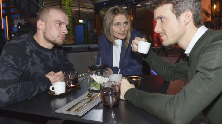 Chris (Eric Stehfest, l.) und Felix (Thaddäus Meilinger) sind überrascht, dass Rosa (Joana Schümer) ihre Geschäfte neu regeln möchte.