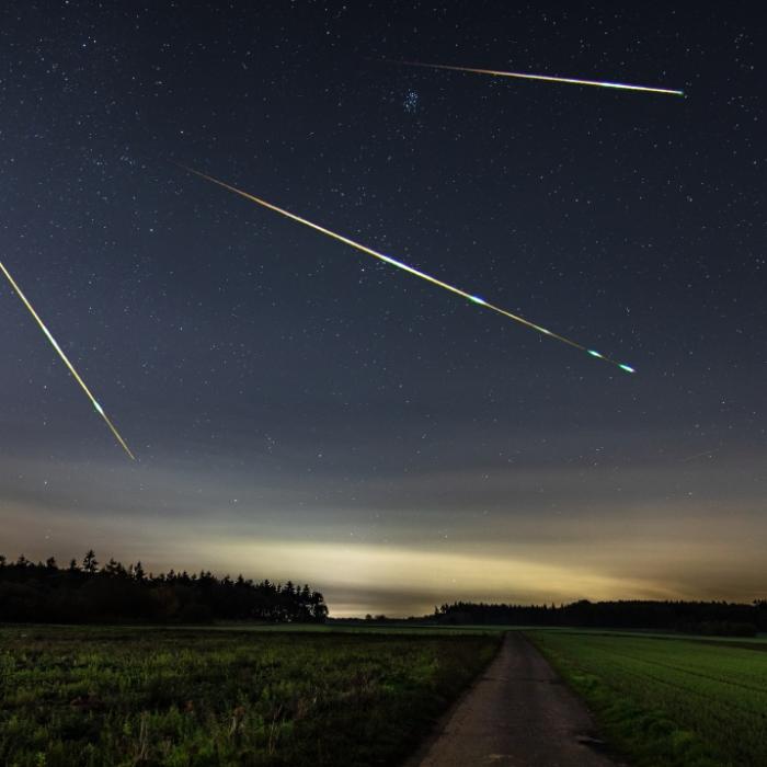 Sternschnuppen funkeln nach rotem Vollmond am Himmel