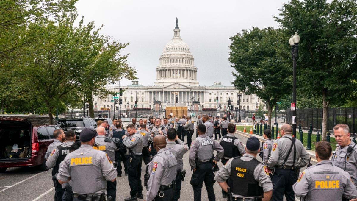 Polizisten versammeln sich vor dem, mit einem Sicherheitszaun abgesperrten, US-Kapitol. Gut acht Monate nach der Erst&uuml;rmung des Kapitols in Washington wollen Anh&auml;nger des damaligen US-Pr&auml;sidenten Donald Trump genau dort erneut aufmarschieren. (Foto)