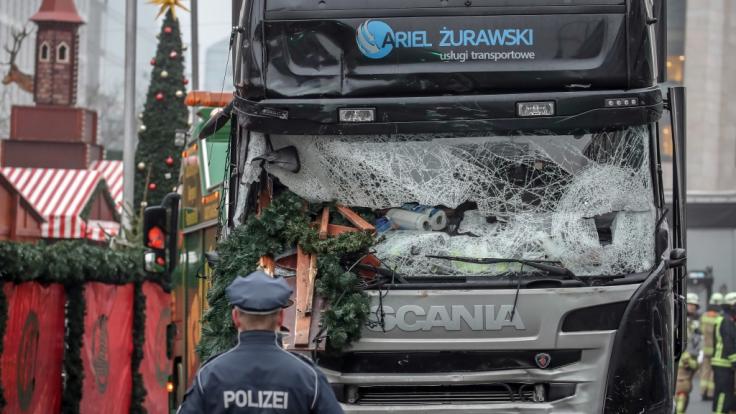 Ein Polizist steht vor dem Tatfahrzeug, einem polnischer Lastwagen, am Weihnachtsmarkt am Breitscheidplatz nachdem der Attentäter Anis Amri mit dem Fahrzeug über den Platz gerast war.