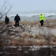 Polizisten suchen in den Dünen von Long Island nach weiteren Mordopfern.