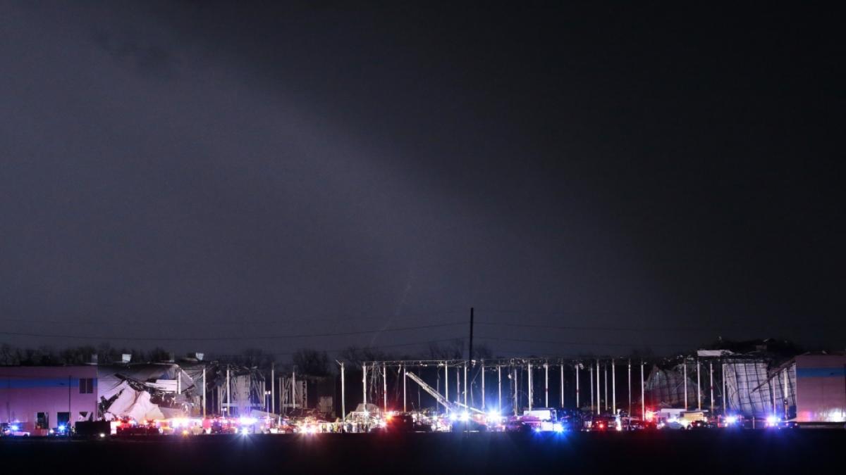 Rettungskr&auml;fte stehen vor dem Amazon-Verteilzentrum, dessen Dach teilweise eingest&uuml;rzt ist. Ein Tornado hat am sp&auml;ten Abend des 10.12.2021 im US-Bundesstaat Arkansas mindestens zwei Menschenleben gefordert. (Foto)