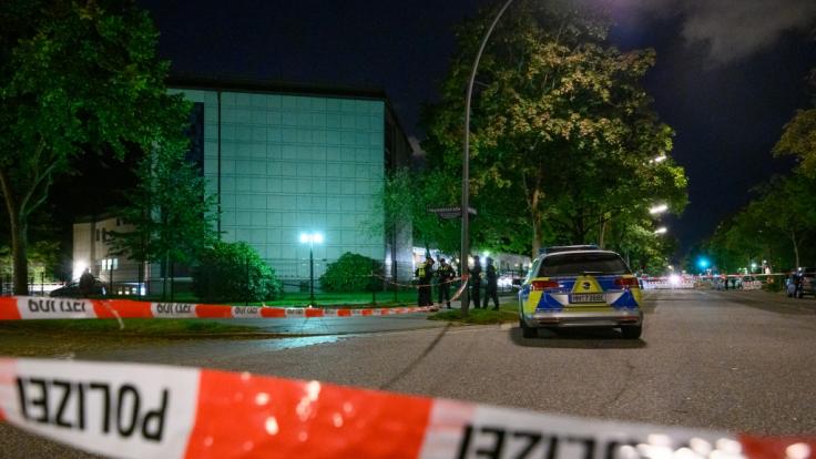 Polizisten stehen am abgesperrten Tatort vor der Synagoge.