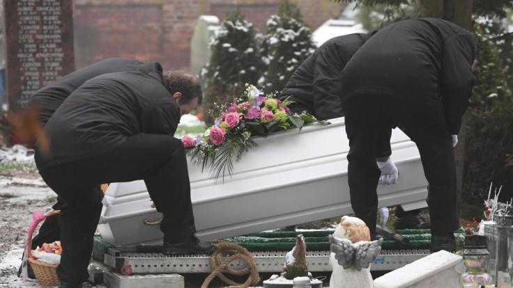 Bestatter senken den Sarg des sechsjährigen Mädchens, das am 12.01.2019 in Torgelow getötet wurde, auf dem Friedhof ins Grab ab.
