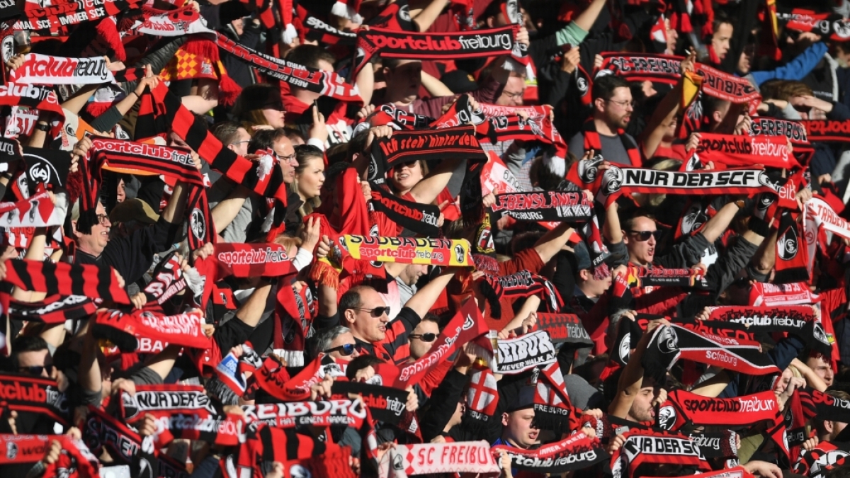 Mit ihren Schals in der Luft unterst&uuml;tzen die Fans vom SC Freiburg ihr Team. (Symbolbild) (Foto)
