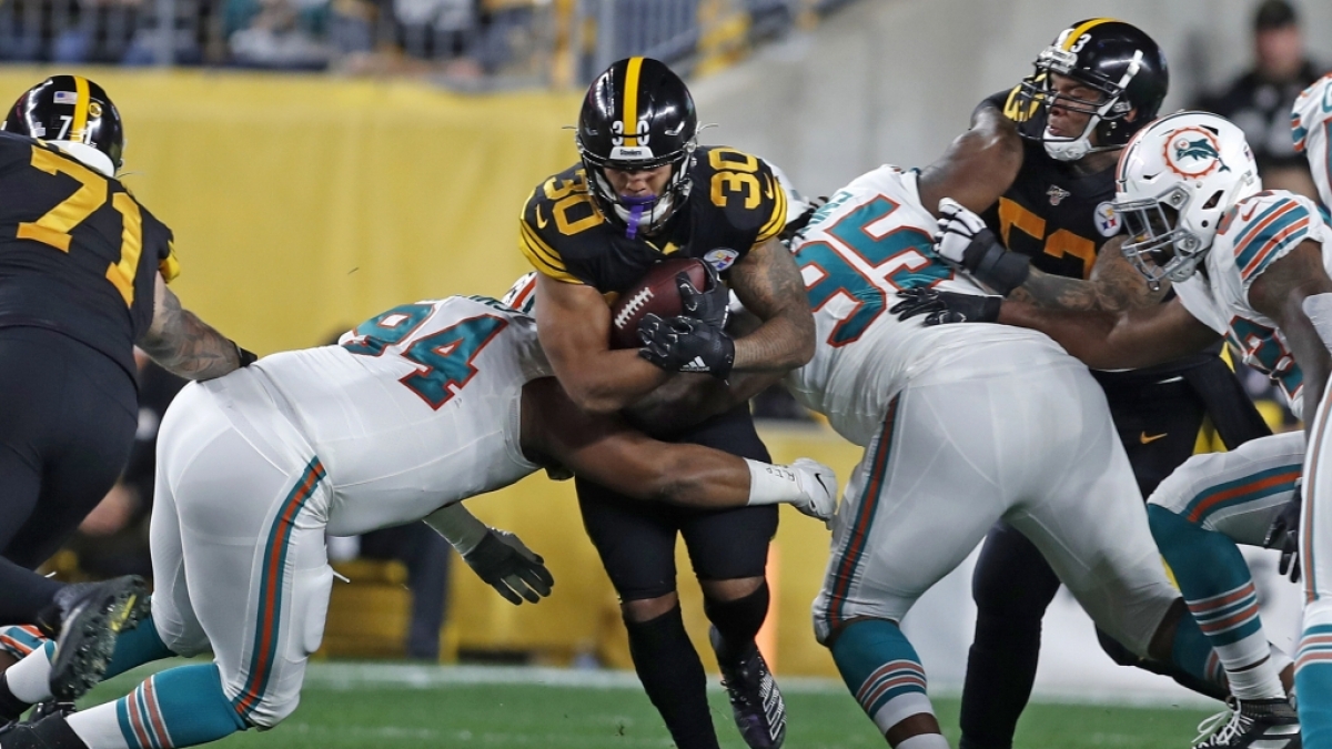 James Conner l&auml;uft den Ball durch zwei Verteidiger der Dolphins am 29.10.2019. (Symbolbild) (Foto)