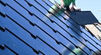 Neuartige Solar-Module: Handwerker arbeiten an einem Photovoltaik Dach