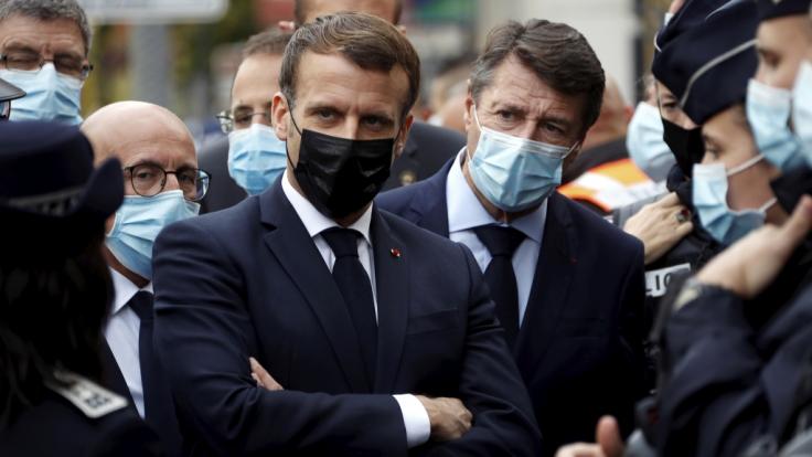 Emmanuel Macron (M, link), Präsident von Frankreich, und Christian Estrosi (M, rechts), Bürgermeister von Nizza, treffen nach einer Messerattacke in der Kirche Notre-Dame in der südfranzösischen Küstenstadt Nizza Polizeibeamte.