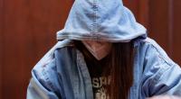 Die angeklagte 17-jährige junge Frau sitzt im Sitzungssaal im Landgericht.
