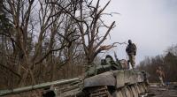 Ukrainische Soldaten posieren auf einem zerstörten Russen-Panzer.