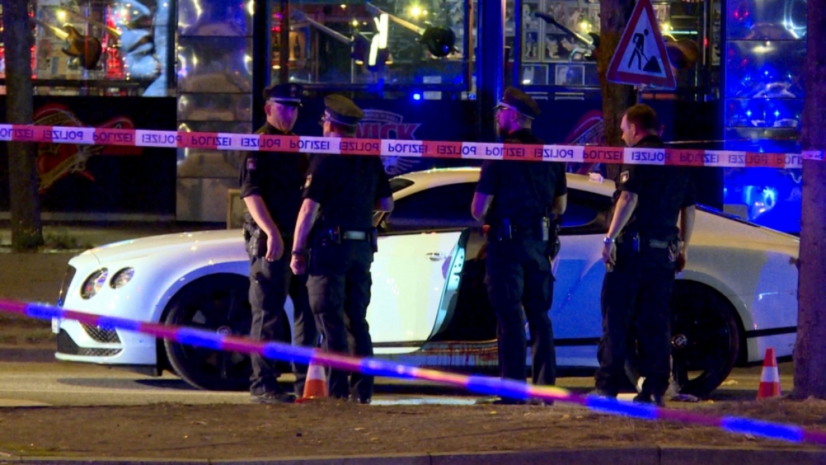 Polizisten stehen neben dem Auto auf dem Hamburger Millerntorplatz, nachdem Sch&uuml;sse auf den Fahrer abgegeben wurden. (Foto)