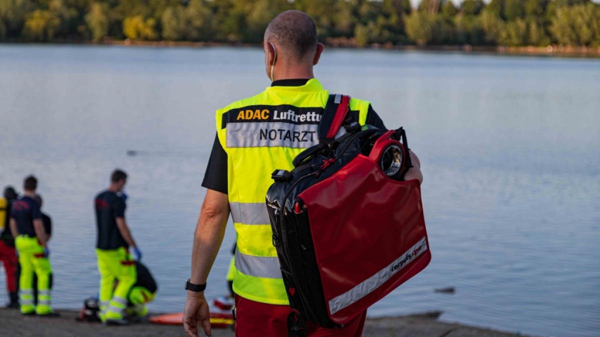 Einsatzkr&auml;fte stehen am Rather See und helfen bei der Bergung eines 13-j&auml;hrigen M&auml;dchens. Das M&auml;dchen war am Mittwochabend mit einer Freundin in dem See geschwommen und pl&ouml;tzlich verschwunden. (Foto)