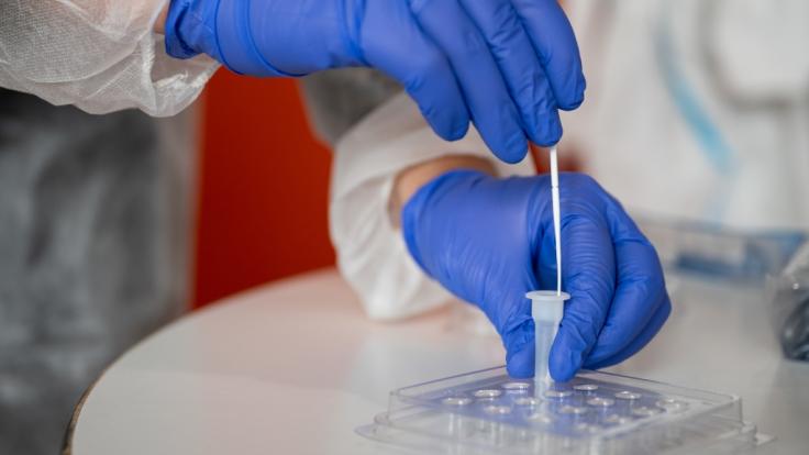 Eine Altenpflegerin führt im Seniorenheim einen Antigen-Corona-Schnelltest durch.