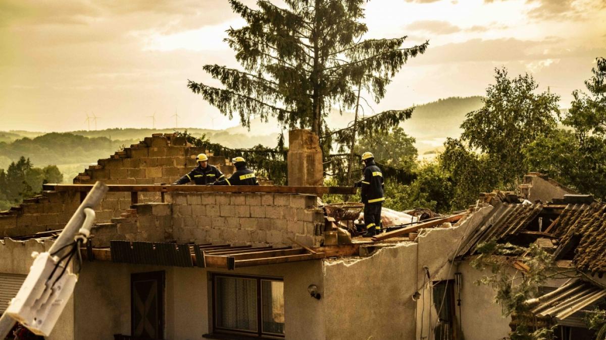 Einsatzkr&auml;fte des THW begutachten Sch&auml;den an einem Haus. (Foto)