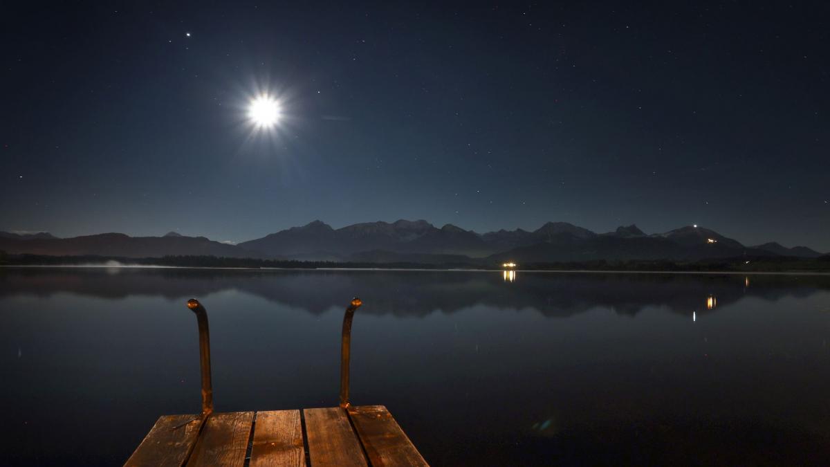 Der zunehmende Mond steht am sternenklaren Himmel &uuml;ber dem Hopfensee. (Foto)