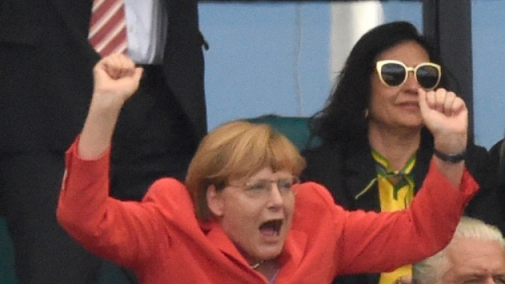Sonst ist Angela Merkel eher die Freundin subtiler Gesten, doch auf der Fußball-Tribüne lässt sie es richtig krachen.