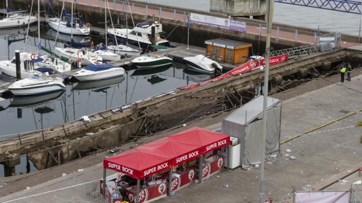 Ein Foto zeigt den zerstörten Holzsteg im spanischen Vigo: Der Steg brach während eines Festivals unter dem Gewicht der Massen zusammen, einige Besucher fielen ins Wasser.