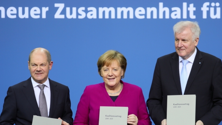 Bundeskanzlerin Angela Merkel (CDU), der CSU-Vorsitzende Horst Seehofer und der kommissarische SPD-Vorsitzende Olaf Scholz zeigen den unterzeichneten den Koalitionsvertrag.