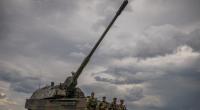 Soldaten stehen vor einem gepanzerten, selbstfahrenden Artilleriegeschütz vom Typ Panzerhaubitze 2000 der Bundeswehr.