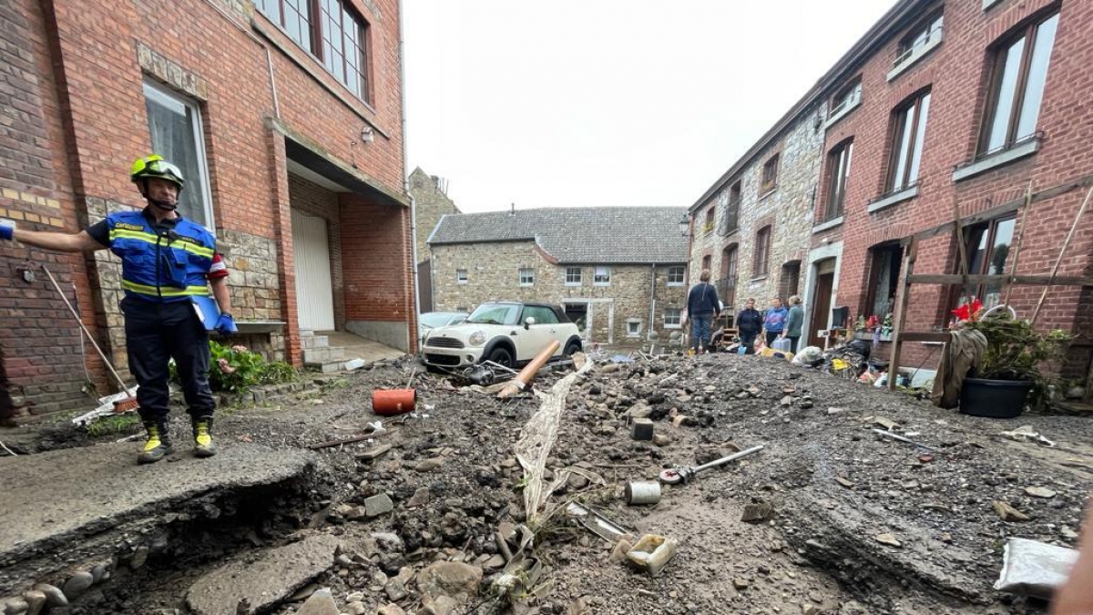 Ein Feuerwehrmann steht an einer, durch die &Uuml;berschwemmungen, aufgerissenen Stra&szlig;e im Raum L&uuml;ttich. (Foto)