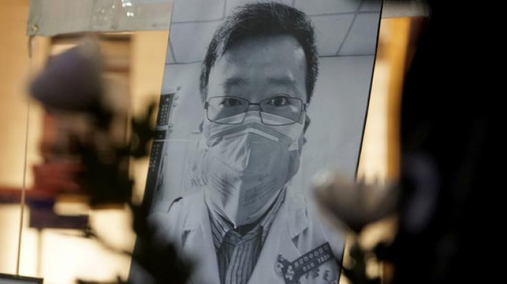 Ein Porträt des chinesischen Arztes Dr. Li Wenliang ist aufgestellt, damit Menschen Blumen niederlegen und trauern können.
