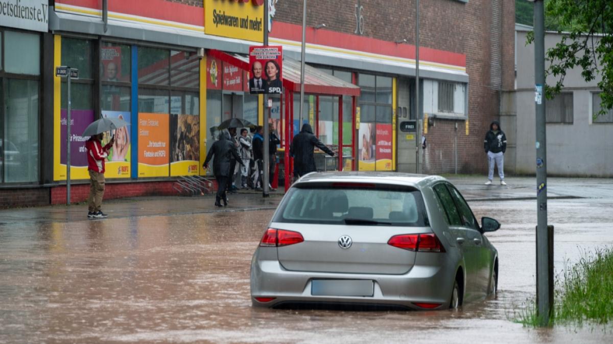 Passanten stapfen und fahren durch das Hochwasser in der Fischbachstrasse in Saarbr&uuml;cken. Nach starken Regenf&auml;llen steht diese teilweise unter Wasser. (Foto)