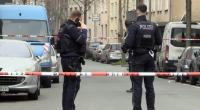 Zwei Beamte stehen an dem abgesperrten Tatort in Duisburg.