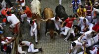 Läufer stürzen beim Stierrennen am 11. Juli 2022 in Pamplona.