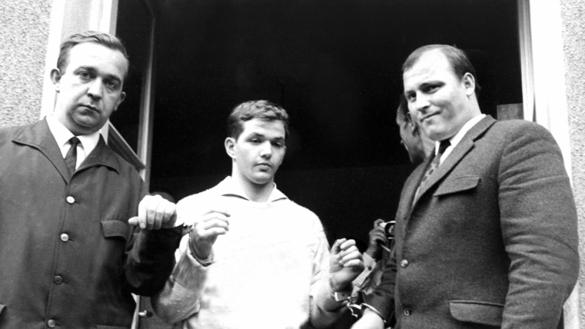 Justizbeamte begleiten J&uuml;rgen Bartsch (M) am 22.6.1966 aus der Polizeistation in Mettmann. Er lockte Kinder in einen unterirdischen Stollen, um sie auf unbeschreibbare Weise zu Tode zu qu&auml;len. (Foto)