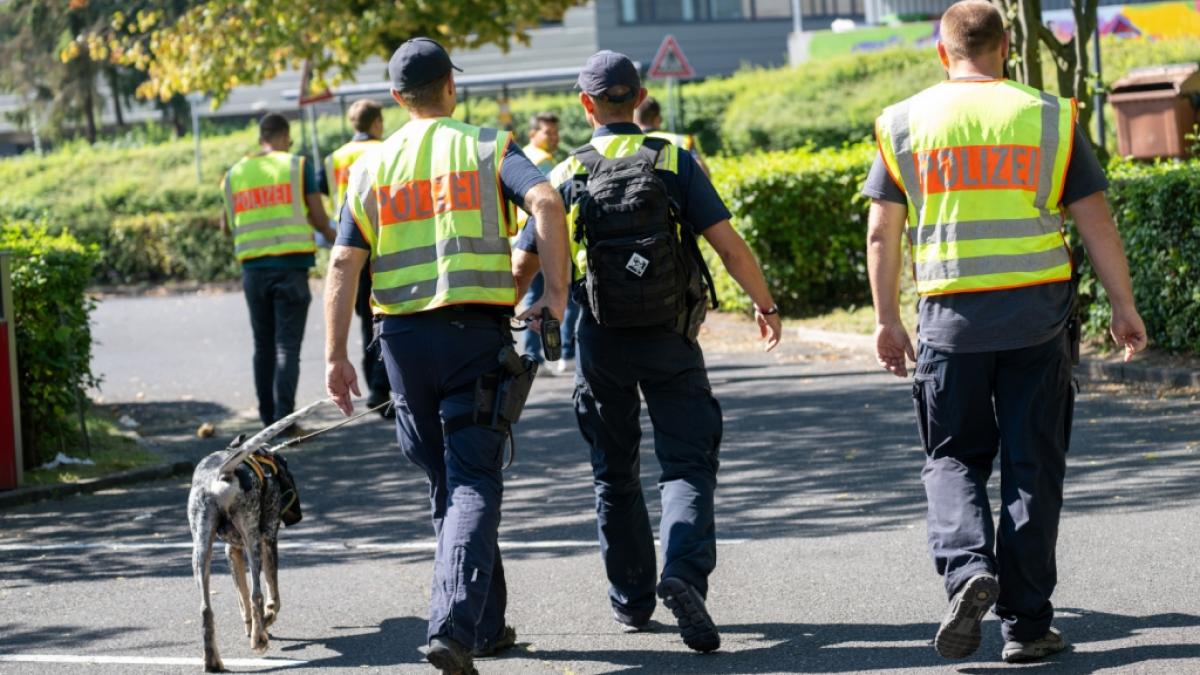 Mit einem Sp&uuml;rhund durchsuchen Polizeibeamte das Gebiet am Schulzentrum in Lohr am Main. Tags zuvor war hier ein toter Jugendlicher gefunden worden. (Foto)