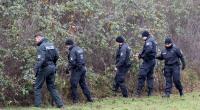 In unmittelbarer Nähe des Fundortes des getöteten achtjährigen Fabian aus Güstrow durchsuchen Polizisten Buschwerk am Wegesrand.