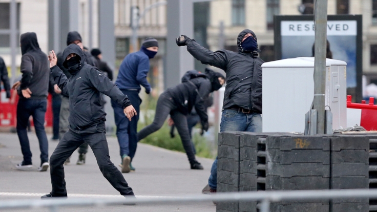 Linksextreme Demonstranten werfen am 26.09. in Leipzig Steine und Falschen auf Polizisten.