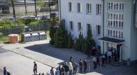 Migranten stehen in einer Schlange in einer Erstaufnahme-Einrichtung.