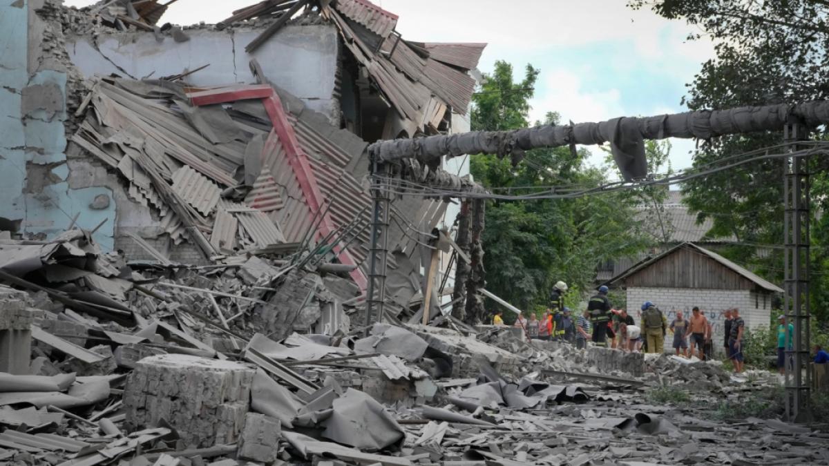 Rettungskr&auml;fte und Anwohner holen nach einem russischen Luftangriff auf Lyssytschansk eine Leiche aus den Tr&uuml;mmern eines Geb&auml;udes. (Foto)