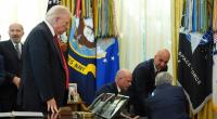 Donald Trump (l.) beobachtet, wie ein Mann bei einer Pressekonferenz im Oval Office vor laufenden Kameras zusammenbricht.