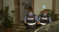Polizeibeamte stehen vor einem Hauseingang. In Saarbrücken ist eine Mutter mit ihren zwei kleinen Kindern von einer Brüstung gefallen.