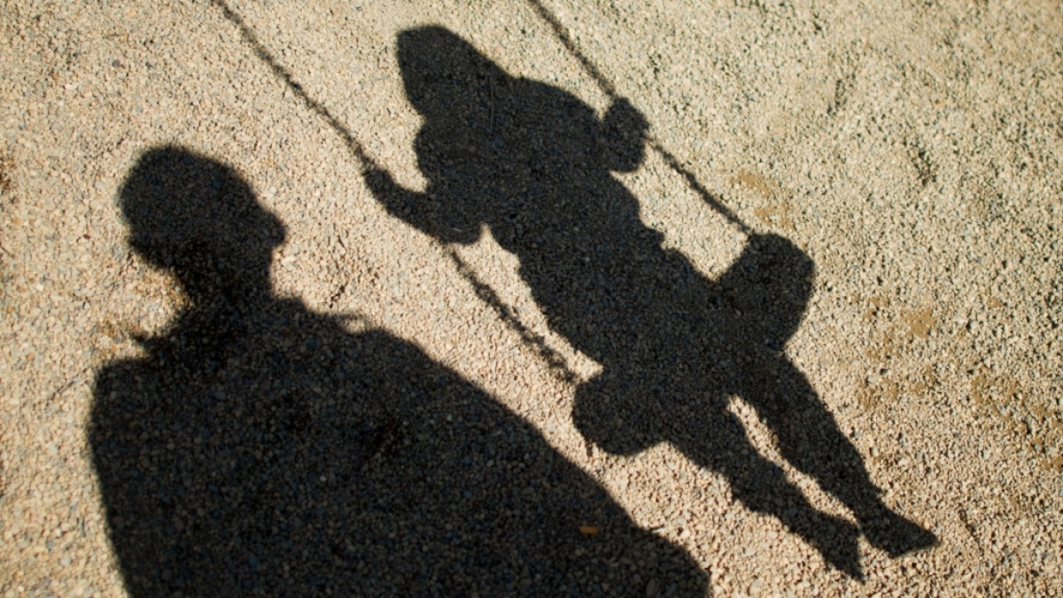 Kindermissbrauch: Schatten von einem Mann und einem Kind auf der Schaukel. (Foto)